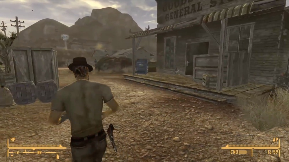A screenshot from Fallout: New Vegas, as a man in a brown shirt and slacks walks through a western town